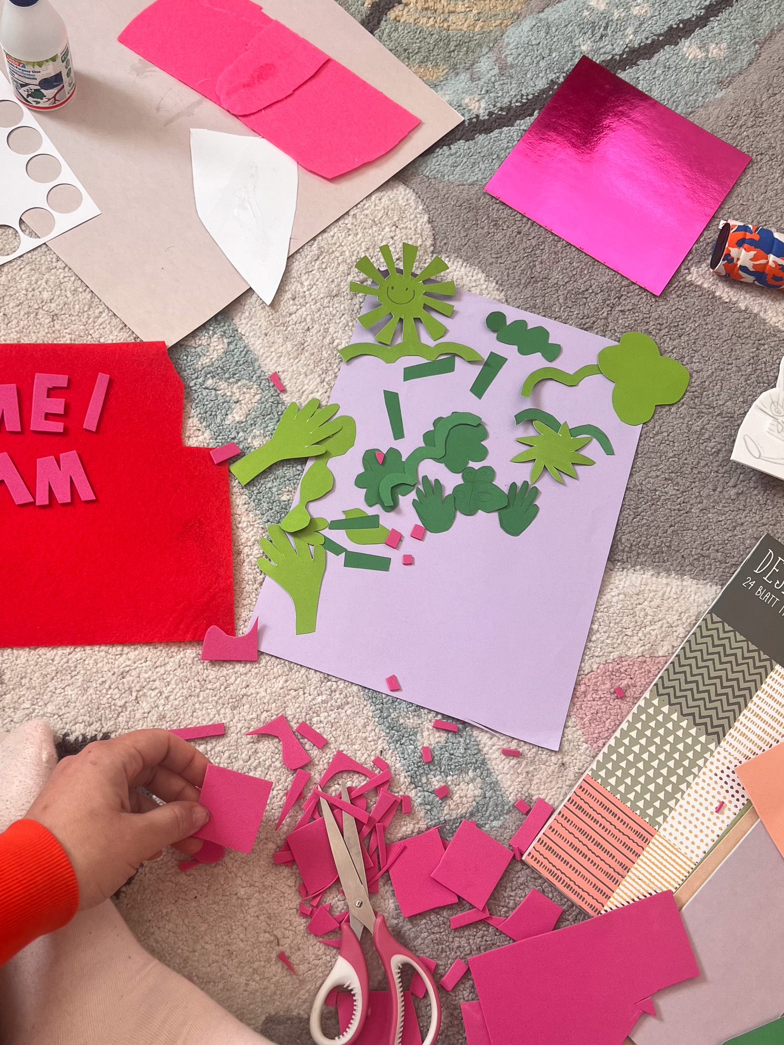 Colorful craft materials scattered on a surface, showcasing creative paper cutouts and scissors for art projects.