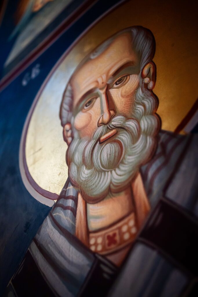 Close-up of a religious icon depicting a bearded figure with a serene expression and traditional attire.