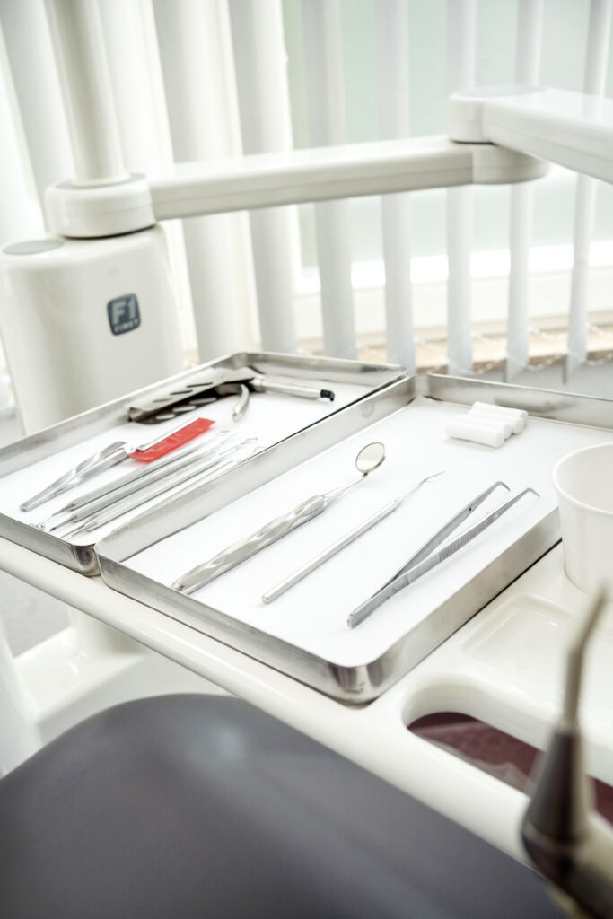 A dental tray showcasing various dental instruments including mirrors, tweezers, and explorers in a clinical setting.